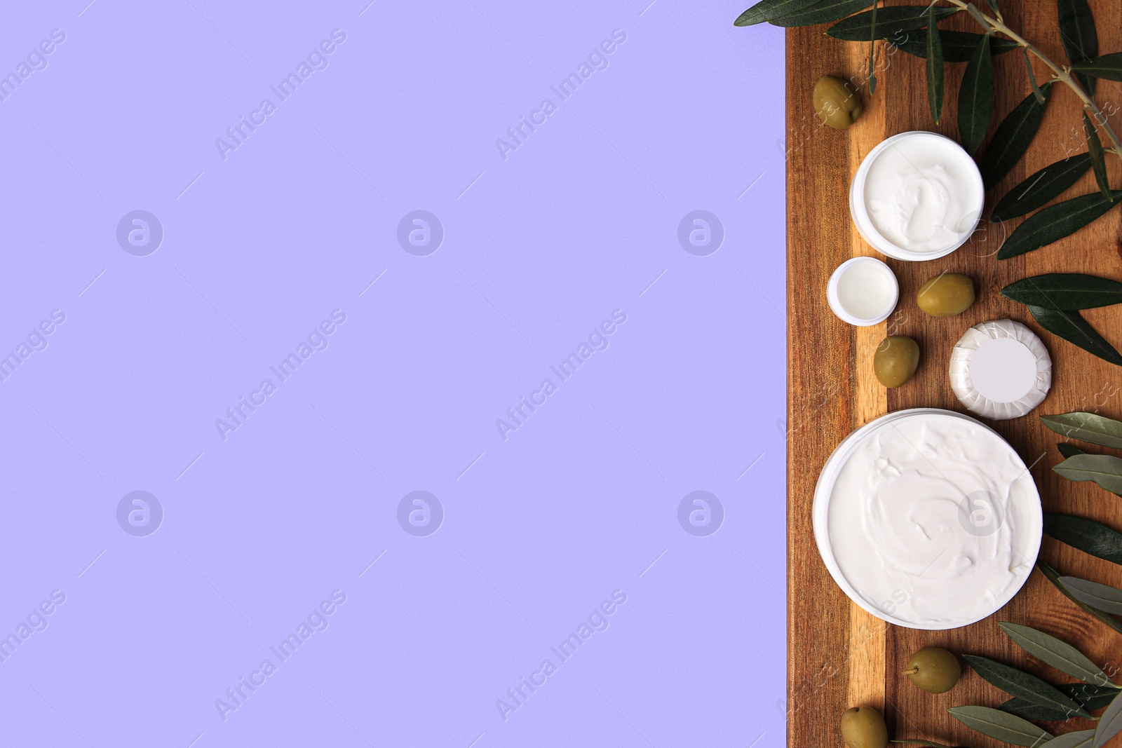 Photo of Different cosmetic products and olives on violet background, top view. Space for text