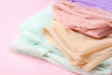 Beautiful colorful tulle fabrics on pink background, closeup