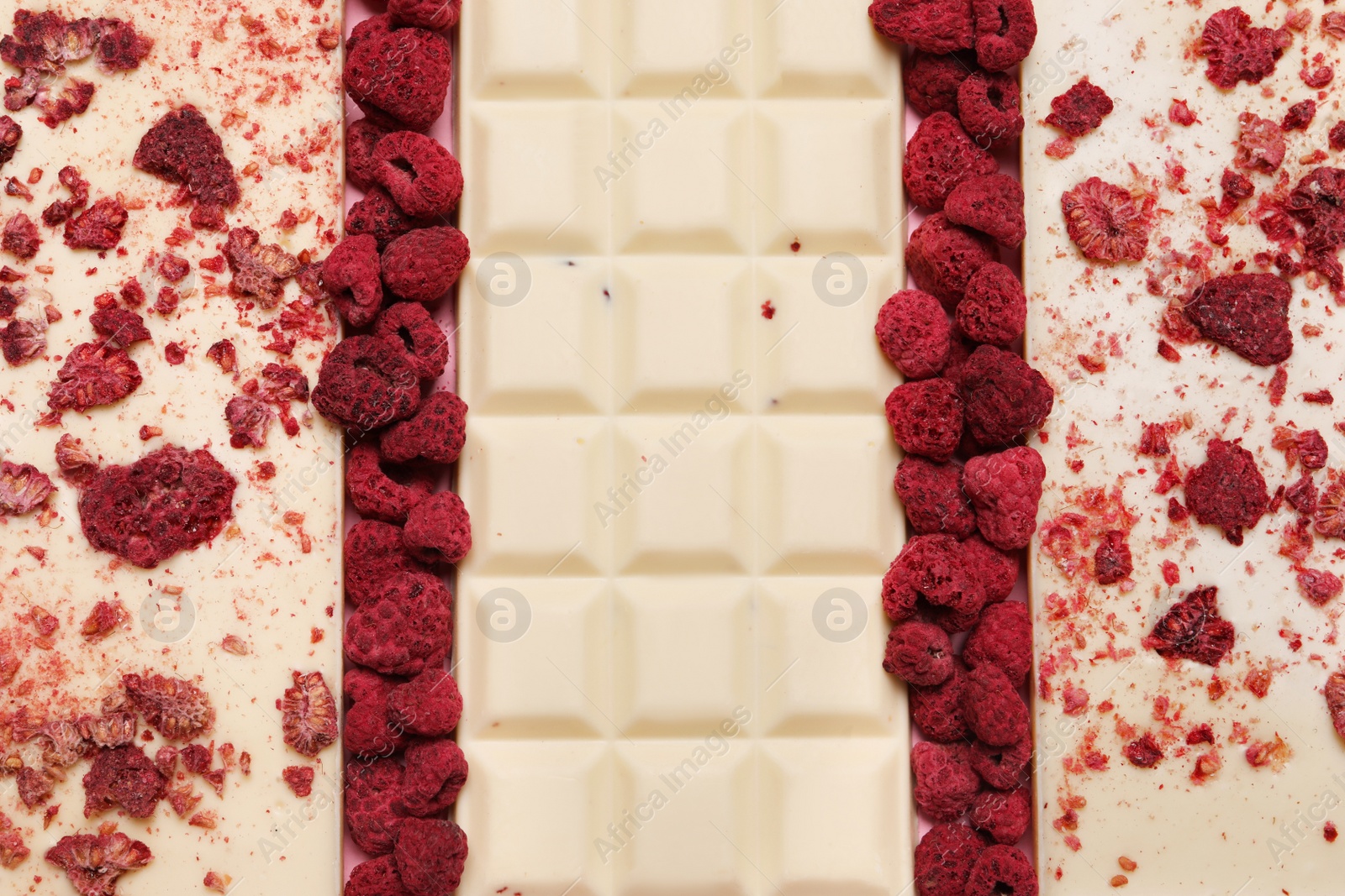 Photo of White chocolate bars with freeze dried fruits as background, closeup