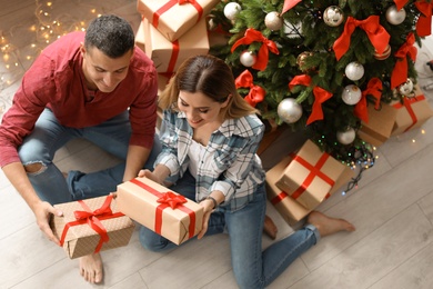 Photo of Young couple with Christmas gifts at home