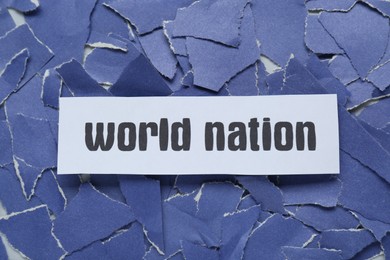 Photo of Words World War on pieces of torn blue paper, top view