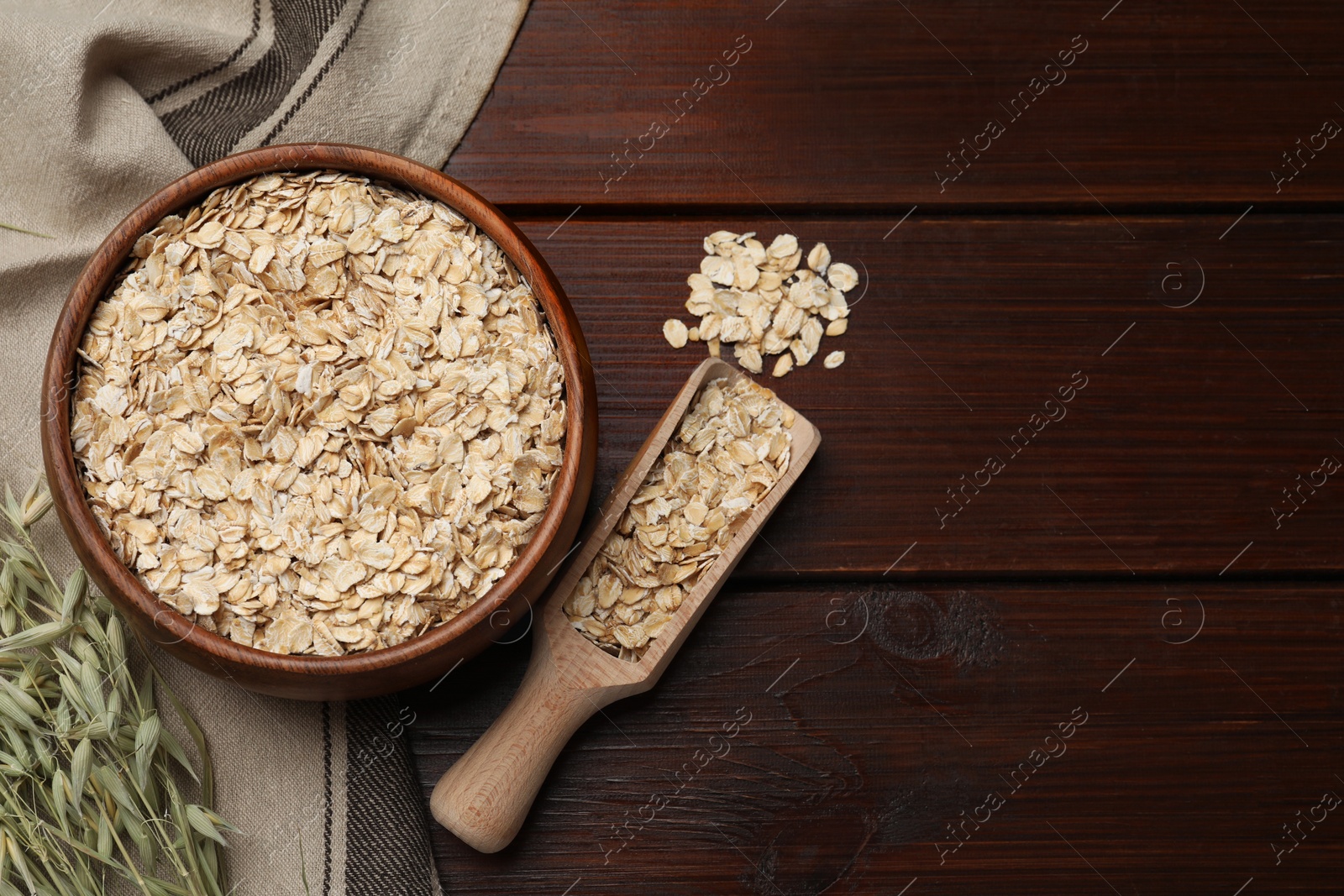 Photo of Oatmeal and branches with florets on wooden table, flat lay. Space for text