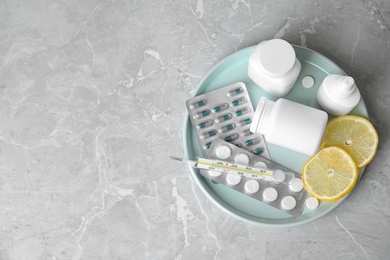 Tray with different cold remedies on light grey marble table, top view. Space for text