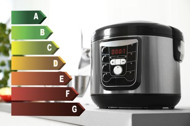 Image of Energy efficiency rating label and multi cooker on table indoors