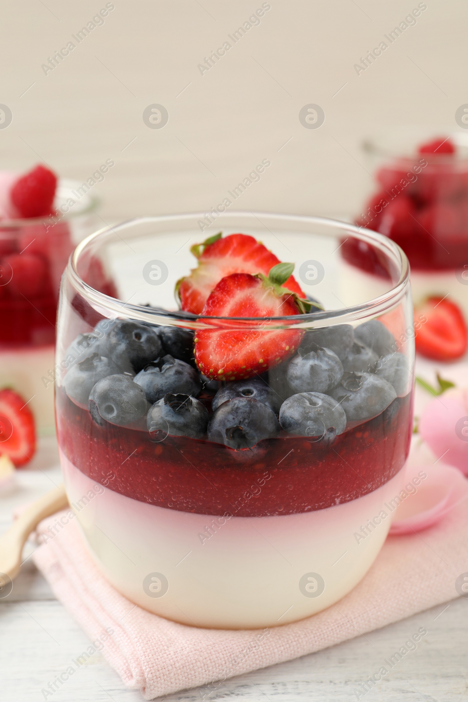 Photo of Delicious panna cotta with berries on white table