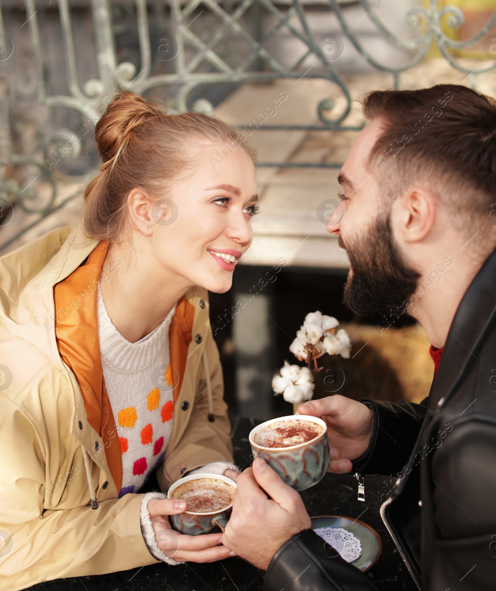 Photo of Lovely young couple enjoying tasty coffee at table outdoors