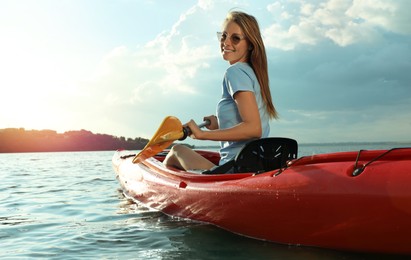 Photo of Happy woman kayaking on river. Summer activity