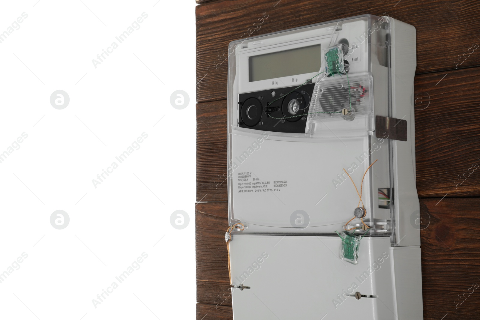 Photo of Electricity meter on wooden wall against white background. Space for text