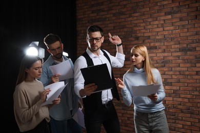 Professional actors reading their scripts during rehearsal in theatre
