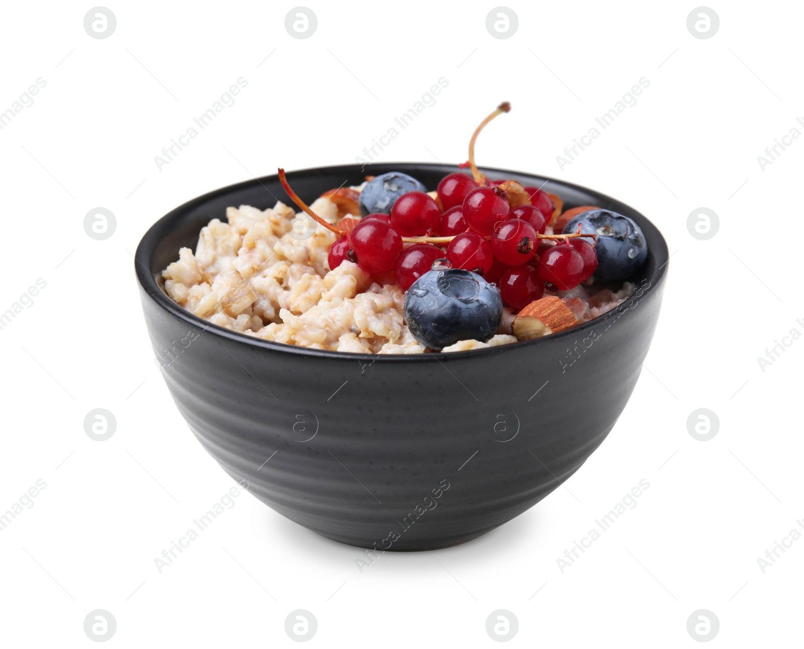 Photo of Ceramic bowl with oatmeal, berries and almonds isolated on white