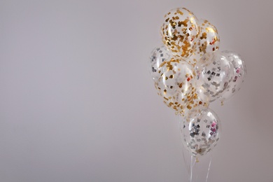 Photo of Bunch of bright balloons on grey background. Space for text