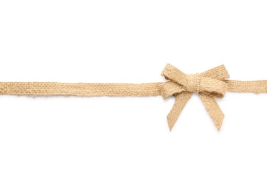 Burlap ribbon with pretty bow on white background, top view
