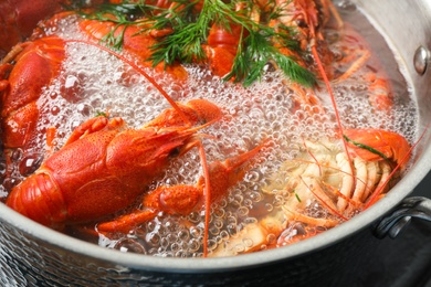 Fresh delicious crayfishes in boiling water, closeup