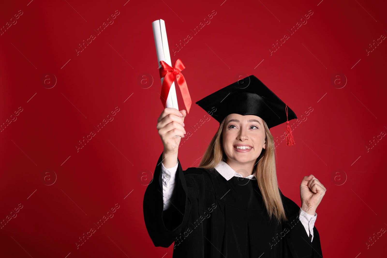 Photo of Happy student with diploma on red background