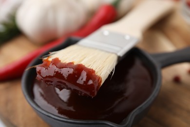Marinade in gravy boat and basting brush on table, closeup
