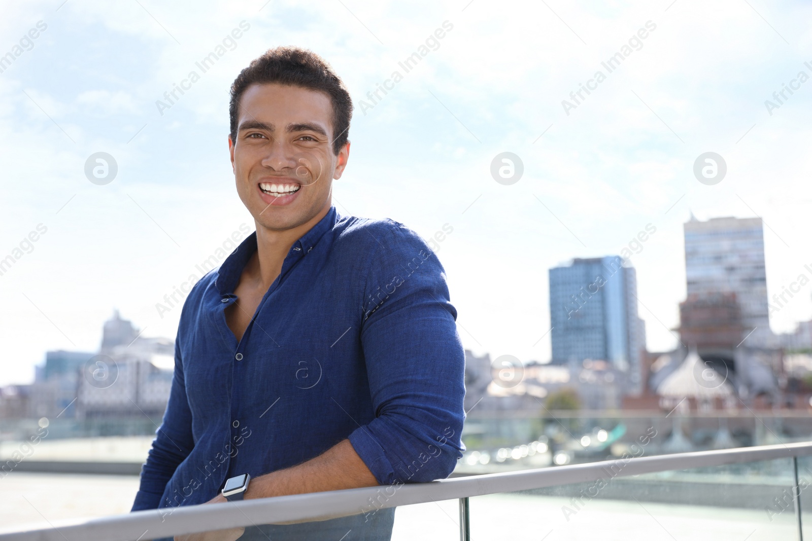 Photo of Portrait of handsome young African-American man on city street. Space for text