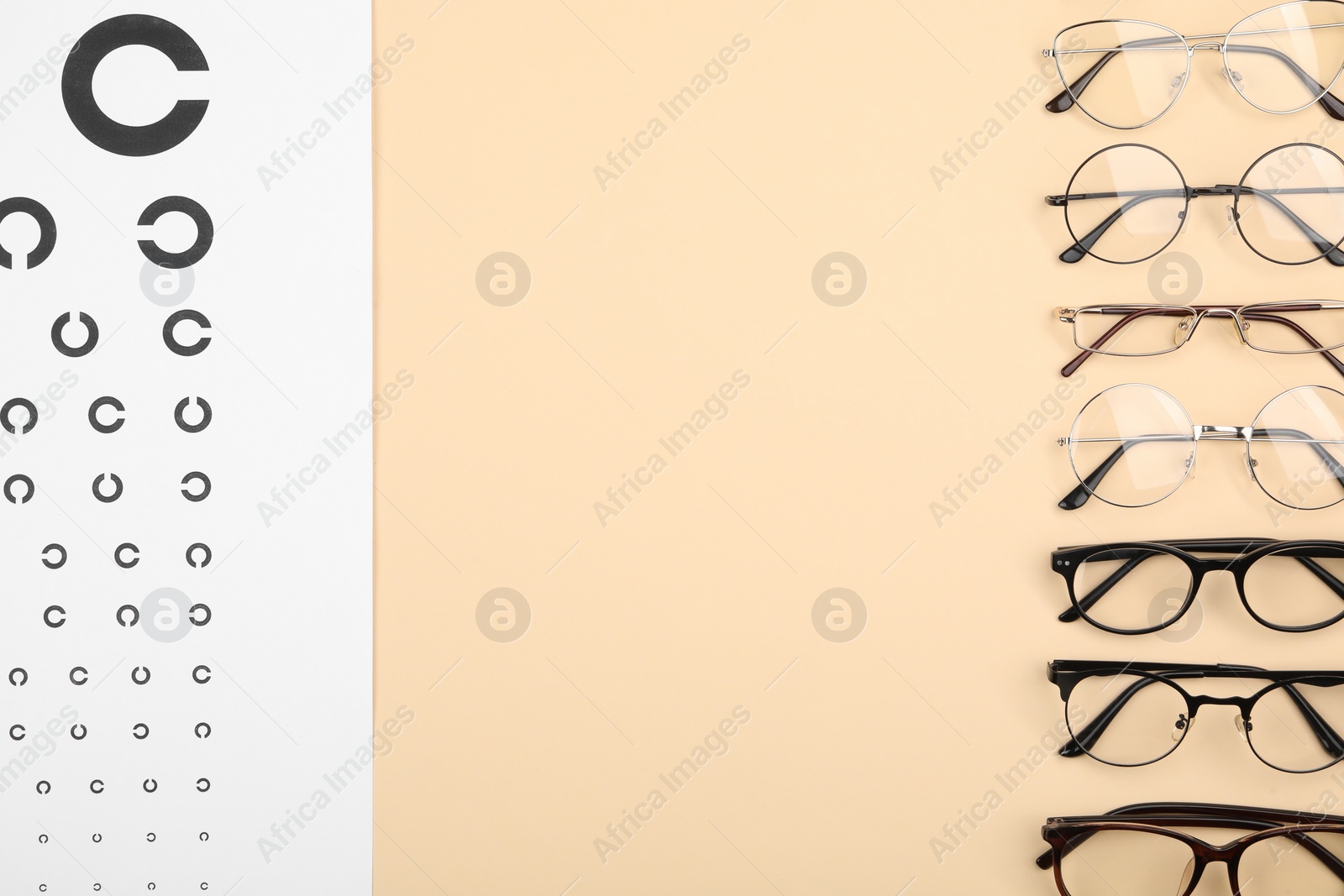 Photo of Vision test chart and glasses on beige background, flat lay. Space for text