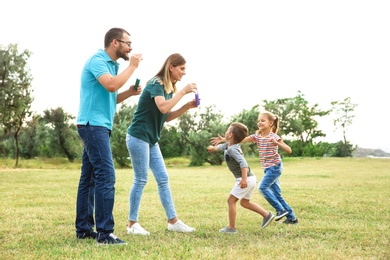 Photo of Happy family playing together with their children outdoors