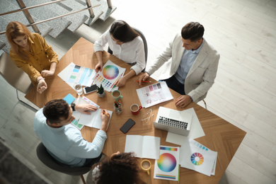 Team of professional designers working together at table in office