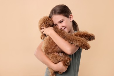 Little child with cute puppy on beige background. Lovely pet