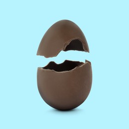 Image of Broken milk chocolate egg on light blue background