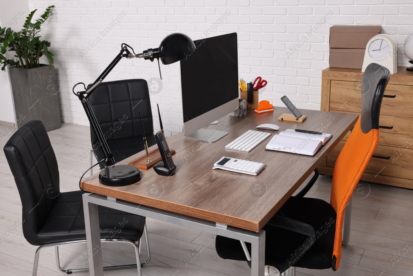 Photo of Stylish director's workplace with comfortable furniture, computer and accessories in office. Interior design