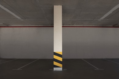 Photo of Empty car parking garage with warning stripes on column