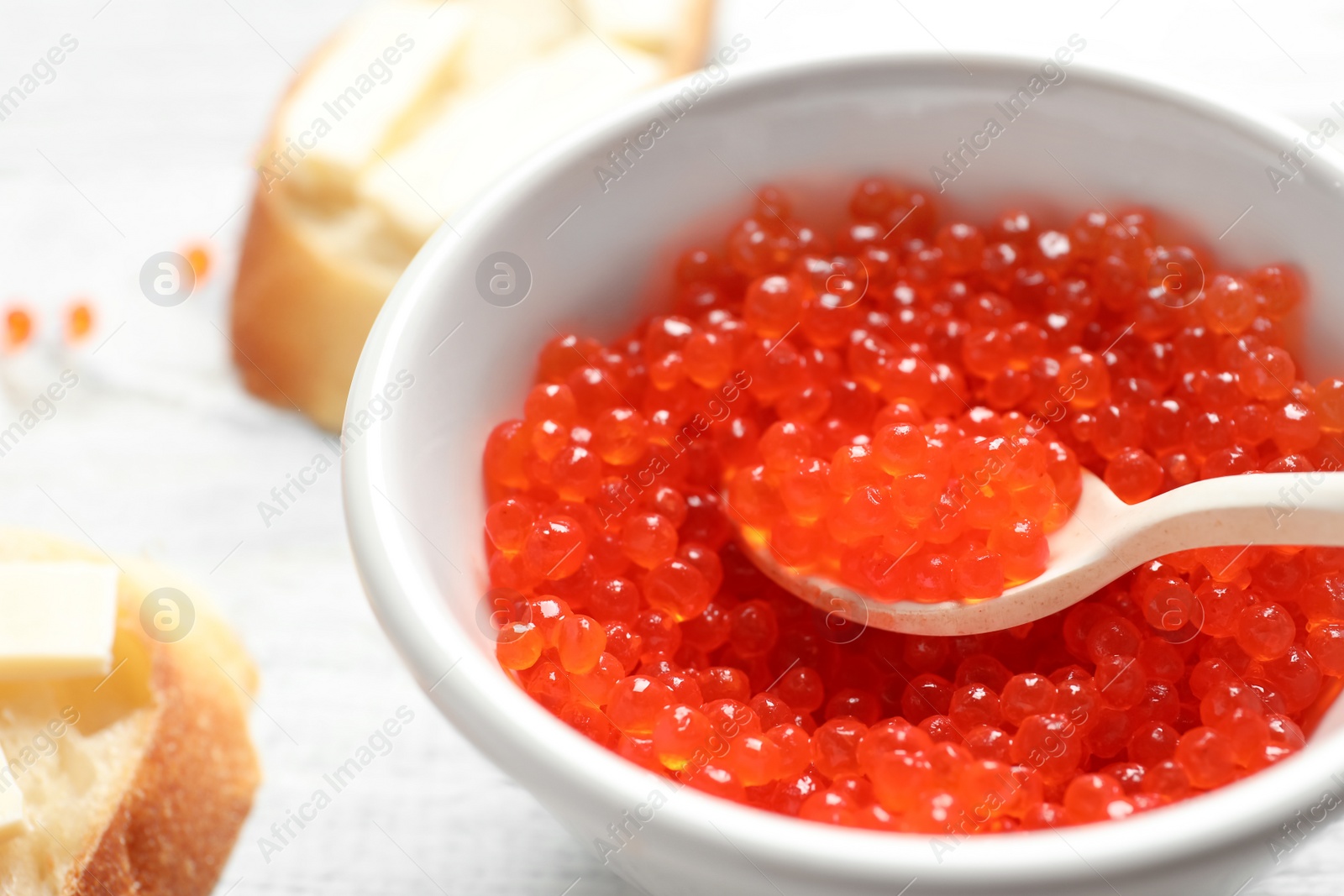 Photo of Bowl and spoon with red caviar, closeup