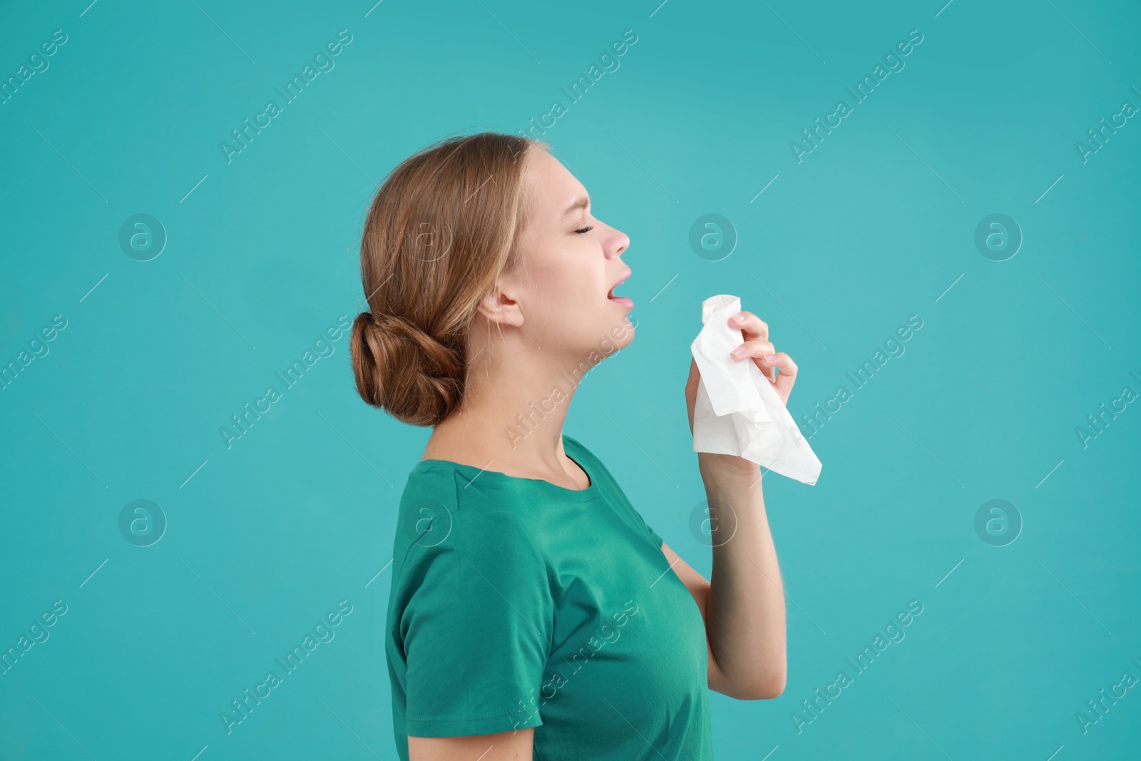 Photo of Young woman suffering from allergy on turquoise background