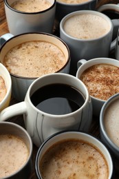 Photo of Many cups of different coffees on table, closeup