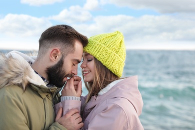 Photo of Lovely young couple near sea. Space for text