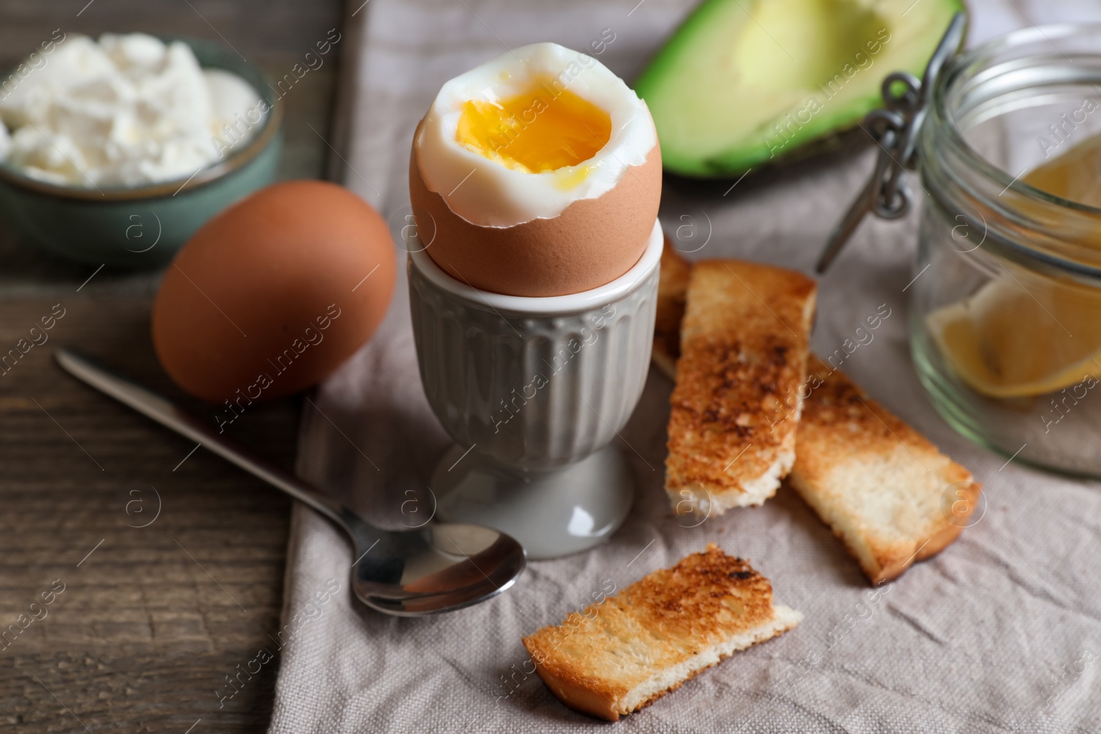 Photo of Soft boiled egg served for breakfast on wooden table