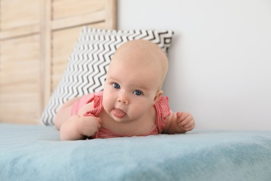 Photo of Cute little baby lying on bed at home