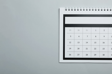 Photo of Paper calendar on light grey background, top view. Space for text