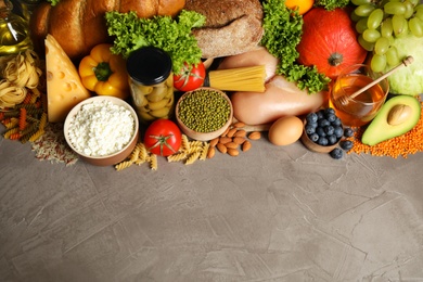 Different products on grey table, above view with space for text. Healthy food and balanced diet