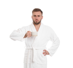 Handsome man in bathrobe with cup of coffee on white background