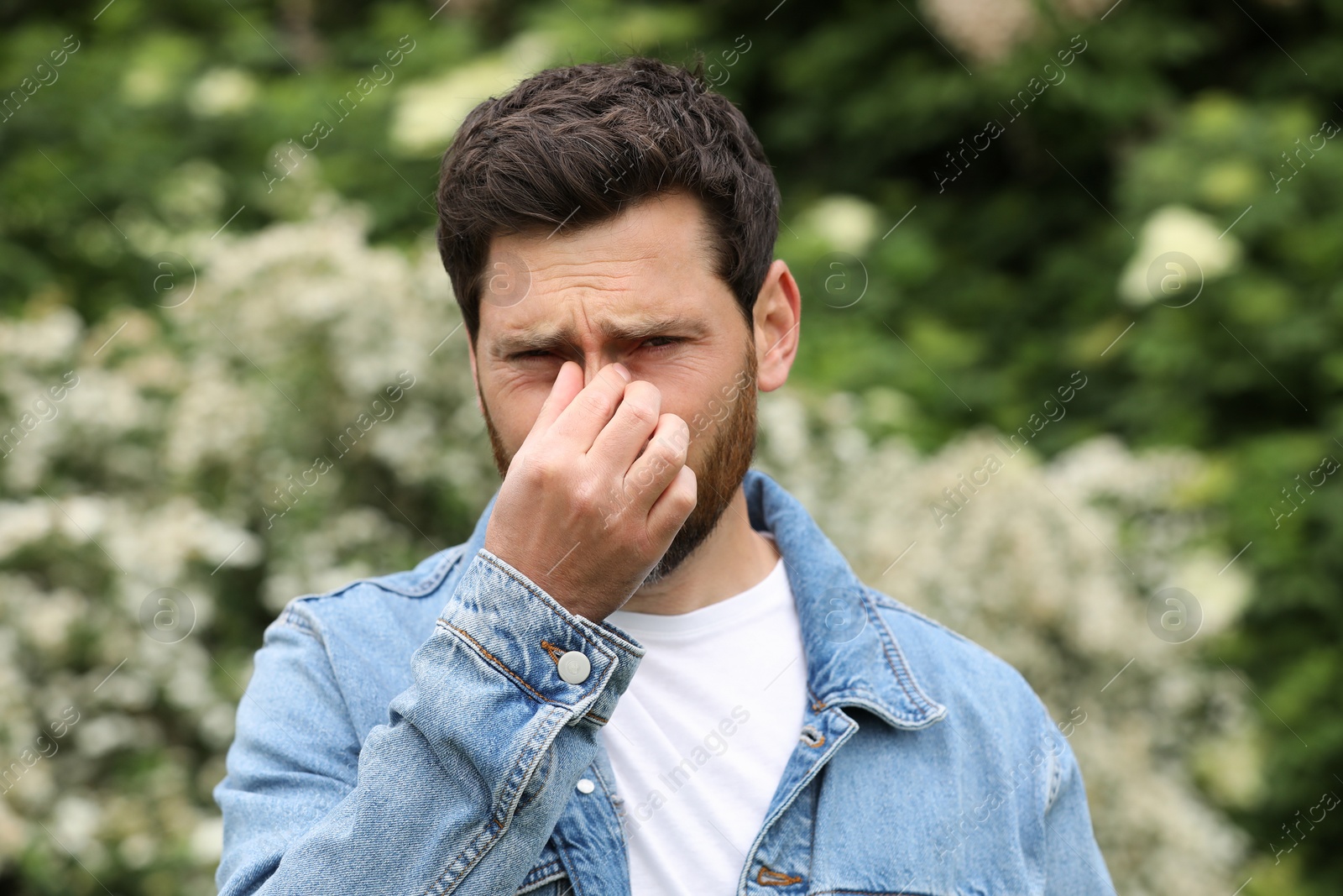 Photo of Man suffering from seasonal spring allergy outdoors