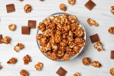 Photo of Flat lay composition with caramel popcorn on white wooden background