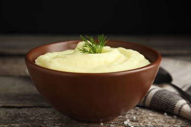 Photo of Freshly cooked homemade mashed potatoes and napkin on wooden table, closeup