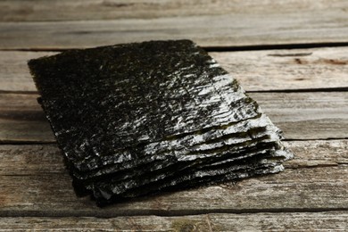 Photo of Stack of dry nori sheets on wooden table