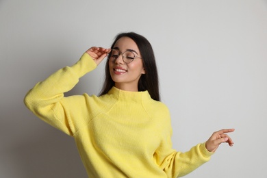 Photo of Beautiful young woman wearing yellow warm sweater on white background