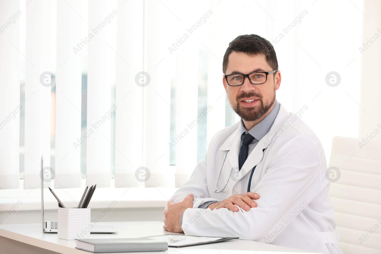 Photo of Portrait of male doctor in white coat at workplace