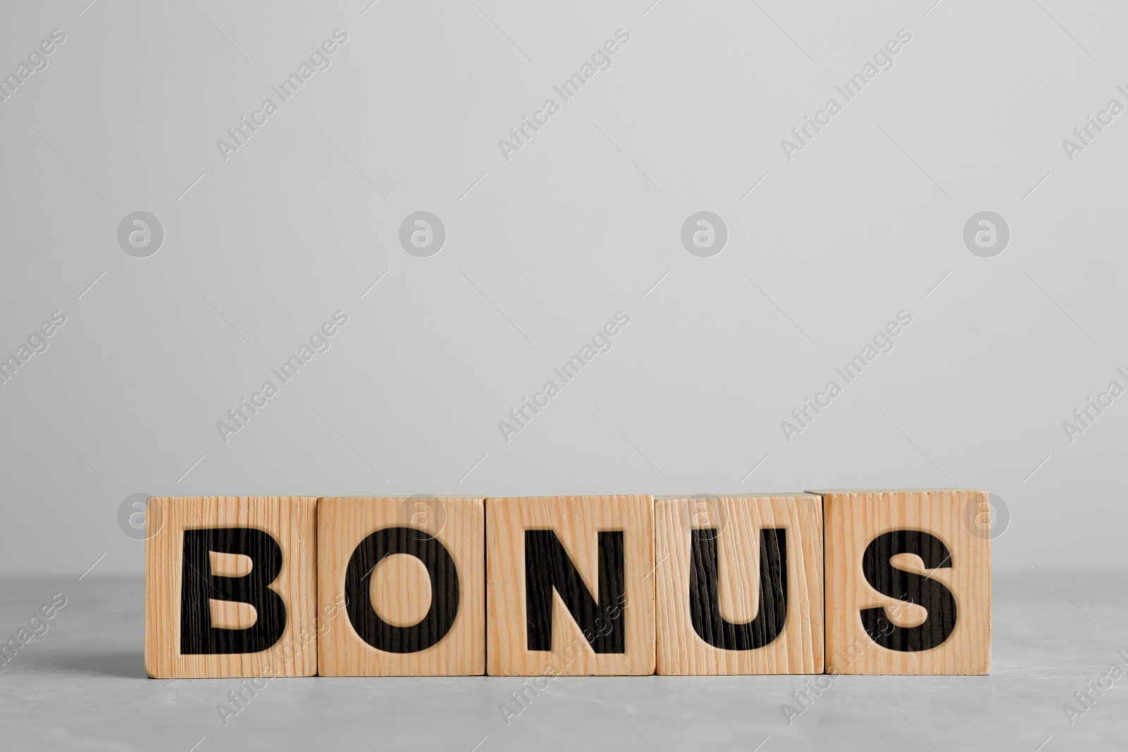Image of Word Bonus made of wooden cubes with letters on white background