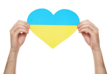 Man holding paper heart in colors of Ukrainian flag on white background, closeup