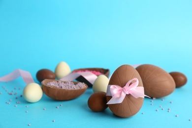 Photo of Sweet chocolate eggs on light blue background. Space for text