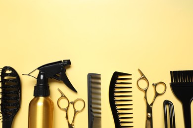 Photo of Hairdressing tools on yellow background, flat lay. Space for text