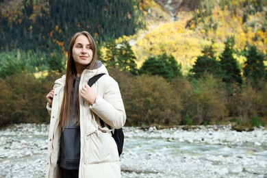 Woman with backpack in beautiful mountains. Space for text