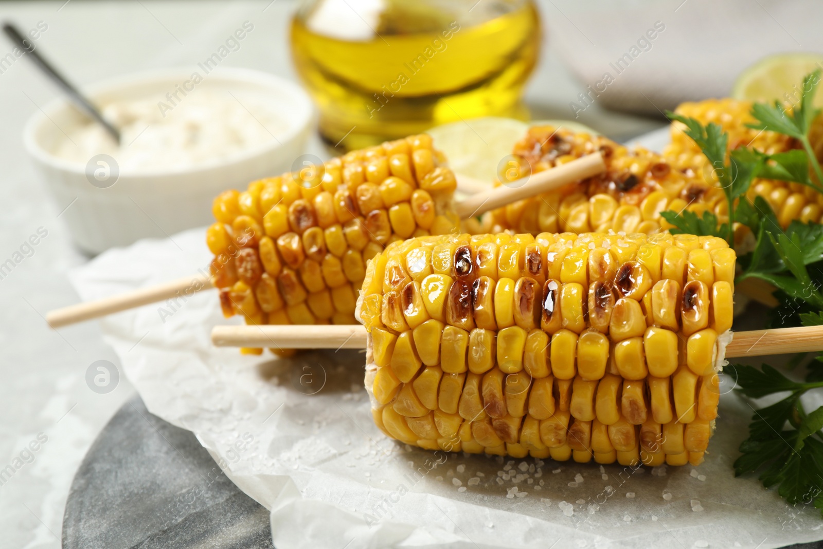 Photo of Tasty grilled corn on table, closeup view