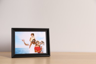 Photo of Frame with family photo on wooden table, space for text