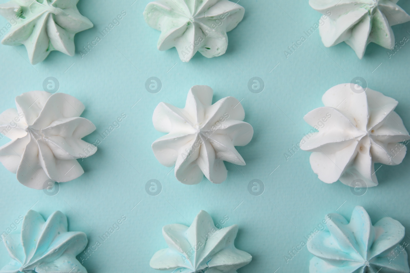 Photo of Delicious meringue cookies on light blue background, flat lay